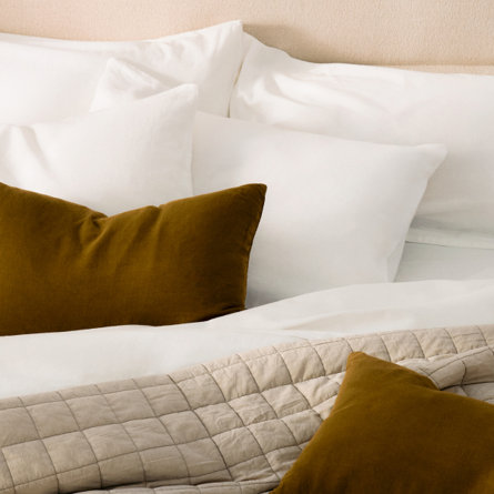 Neutral bedroom with gingham bedding and mustard yellow pillows.
