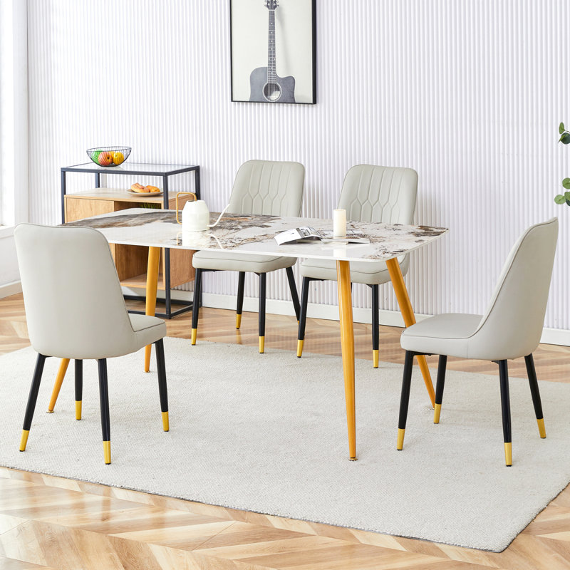 Ensemble de table et de chaises. Table de salle à manger moderne minimaliste.  Bureau imitation marbre à motif de pierres frittées avec pieds en métal doré et 4 chaises confortables avec sièges en polyuréthane et pieds en métal.