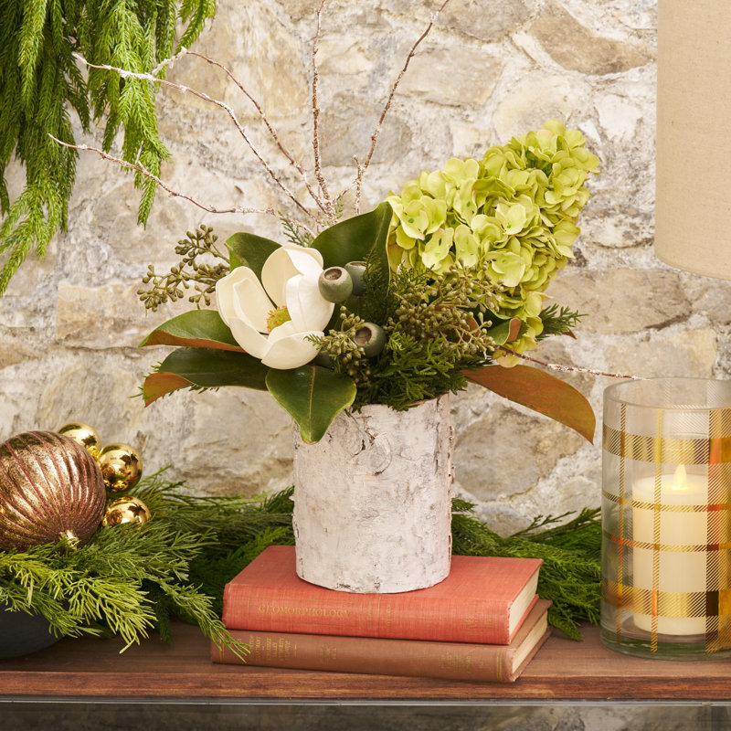 Magnolia des bois - hortensia vert, floraison de magnolia blanc, feuille de toucher véritable et verdure mélangée dans un arrangement de vacances de Noël en cylindre de bouleau blanc