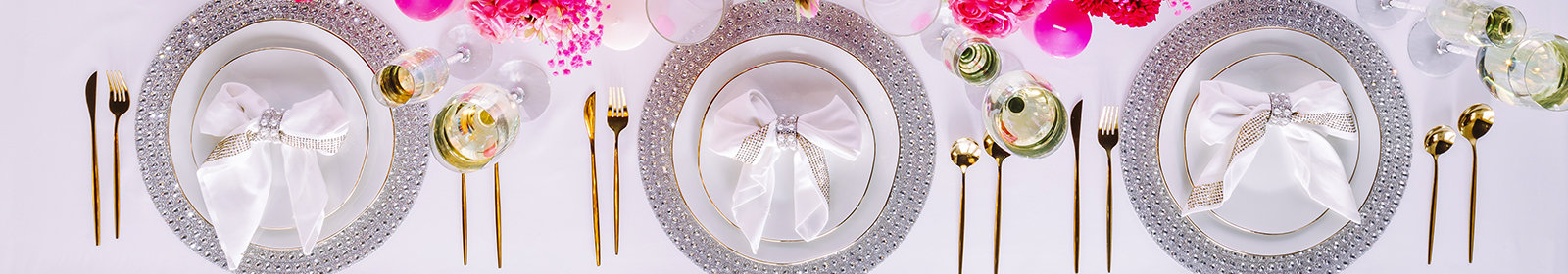 Three place settings featuring clear rhinestoned placemats and bow-folded napkins.