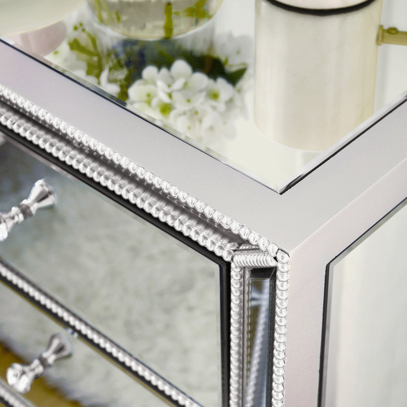 Meuble à trois tiroirs avec fini miroir perlé, idéal pour un rangement élégant et une utilisation multifonctionnelle dans les maisons modernes.