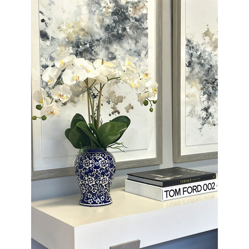 Orchid Arrangement In A Ceramic Vase With Leaves