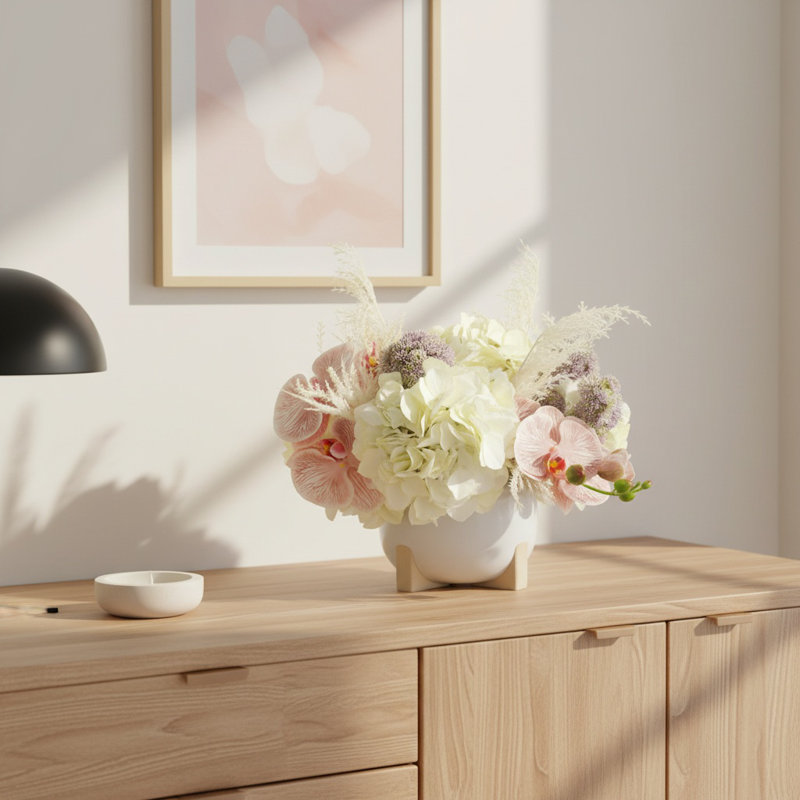 Hortensias, pampas et sédums disposés dans un pot en céramique