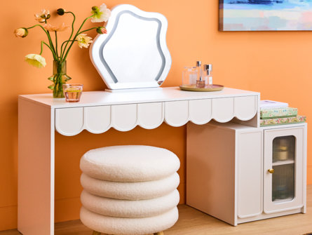 White scallop-edged vanity with mirror and round stool.