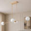 Lustre linéaire chic en laiton à 4 lampes en verre globe