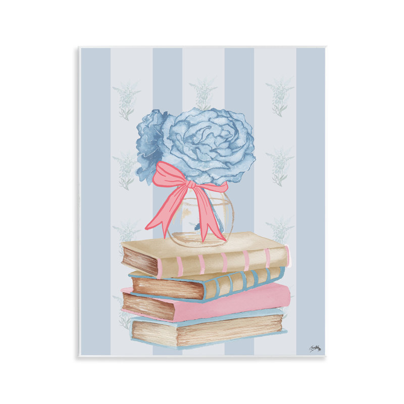Livres empilés et plaque murale d'hortensias bleus, design par Elizabeth Medley