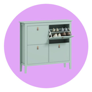 Sage green shoe storage cabinet with four compartments and leather-look pull handles, featuring one open compartment revealing rows of stored shoes against a solid purple circular background.
