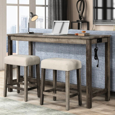 Ensemble de bar transitionnel 3 pièces : table en bois massif avec prises, 2 tabourets beiges rembourrés dans un coin repas rustique, prise électrique, chêne antique, ambiance intime