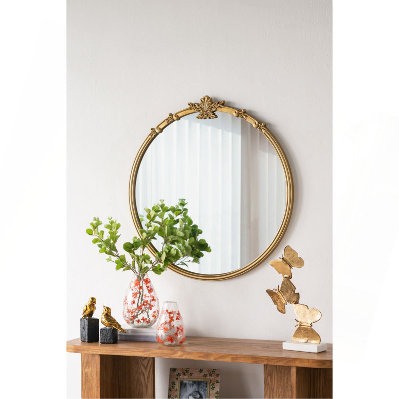 Miroir mural rond avec finition dorée et écusson décoratif