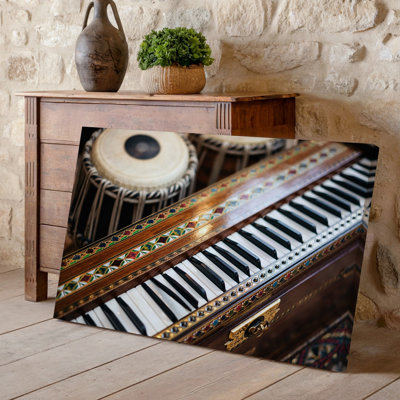 Toile vue rapprochée d'un harmonium magnifiquement confectionné avec art mural, incrustations de bois complexes et motifs éclatants mettant en vedette l'art mural sur toile