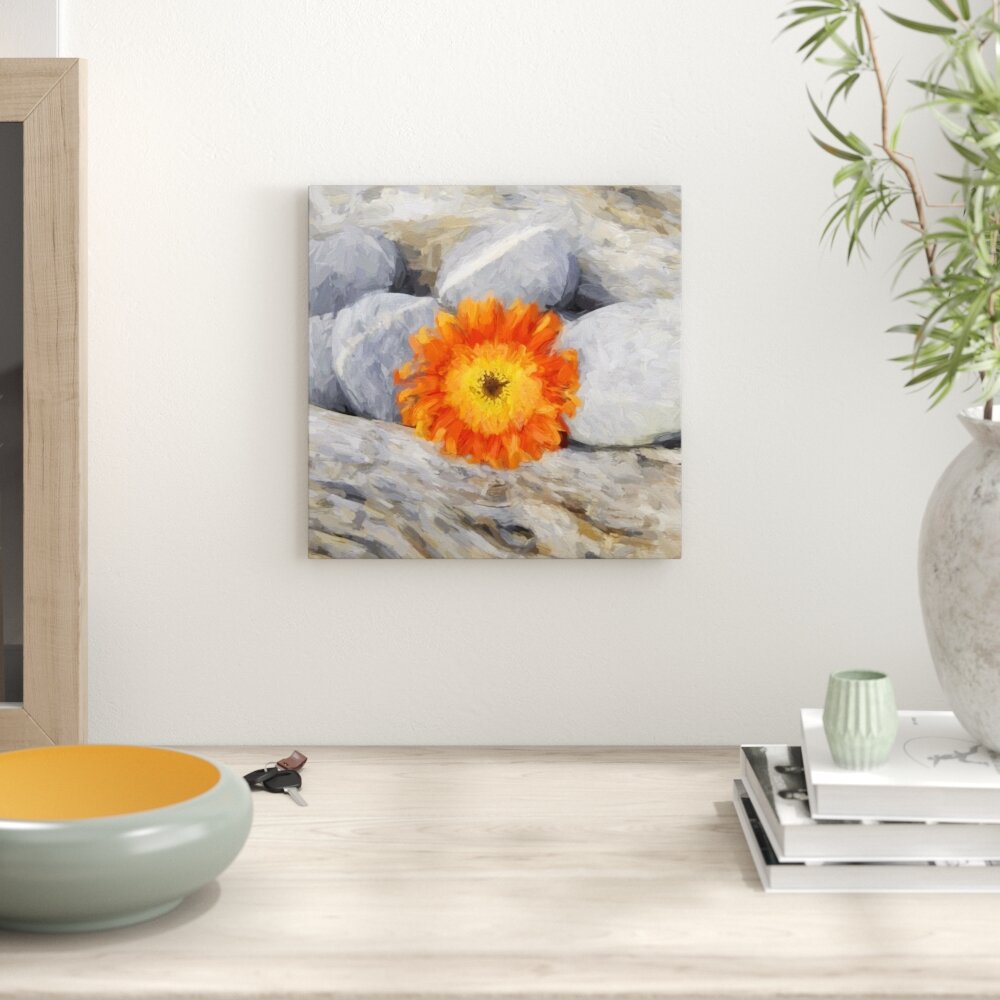 Leinwandbild Kleine Gerbera zwischen Zen Steinen