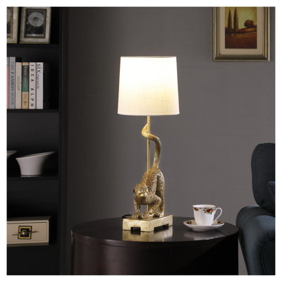 24" Capuchin Monkey Table Lamp with Gold Polyresin Base and White Fabric Shade.