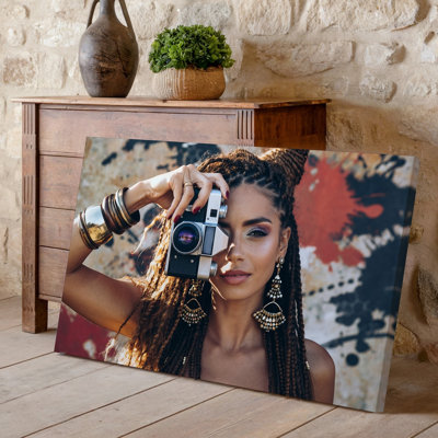 Toile «A Striking Portrait of a Woman with Long Intricately tressé», art mural tenant un appareil photo rétro sur son visage