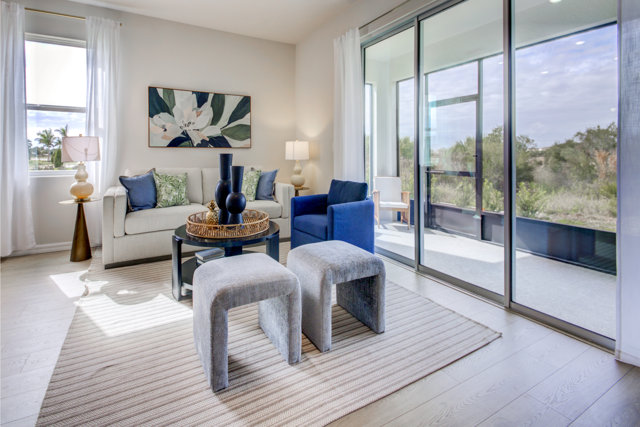 Living room with white sofa, blue cushions, and sliding glass doors to outdoor space.