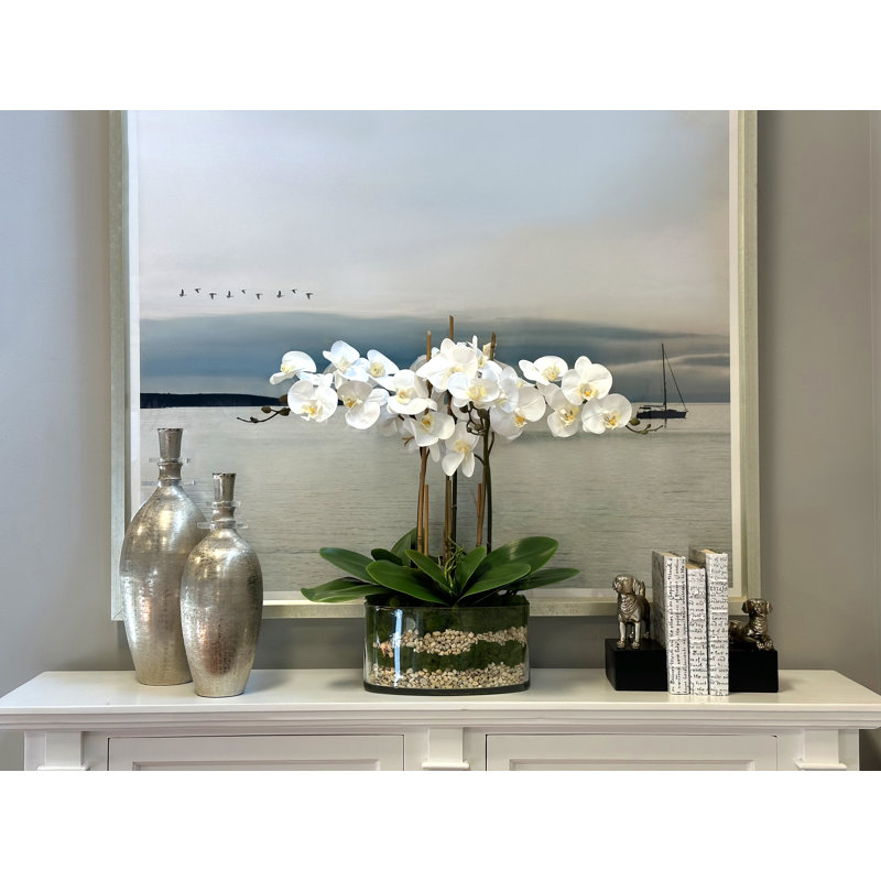 Orchids And Leaves Arranged In An Oblong Clear Glass With Moss And Rocks