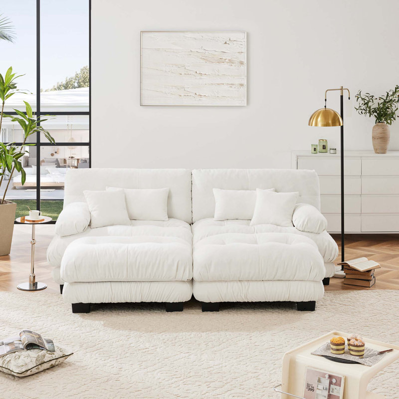 Canapé confortable en chenille avec plusieurs coussins et repose-pieds pour le salon