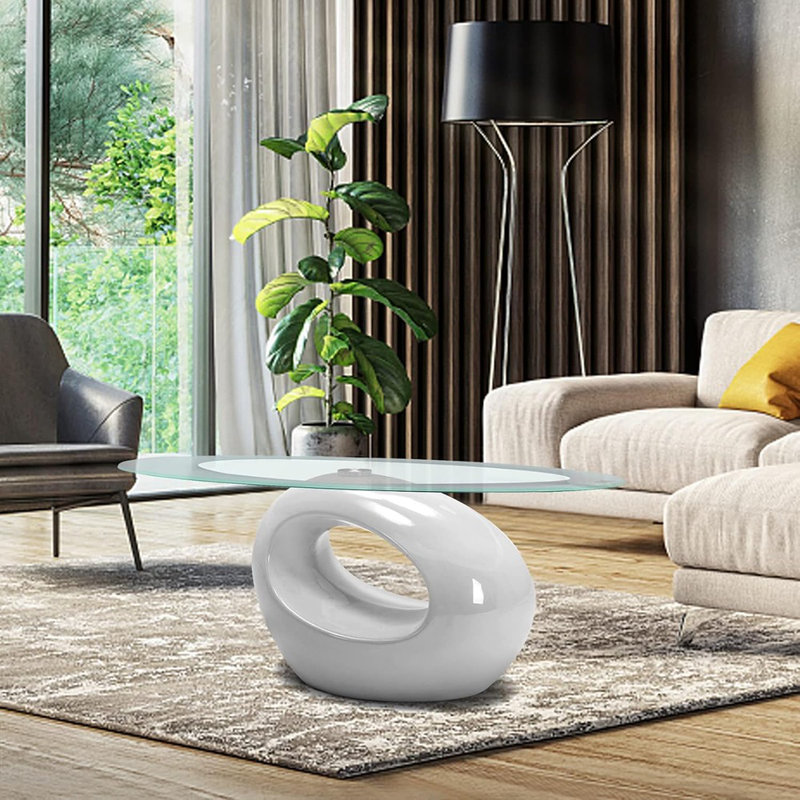 Maxaya The Modern Glass Coffee Table For The Living Room Is An Oval Glass Table Set With A Glossy Solid Base And Tempered Glass Top For Storage. It Is Available In White Color.