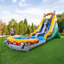 T-rex themed inflatable water slide with a detachable pool and children playing in a backyard