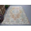 De douces couleurs pastel illuminent les motifs floraux élégants de ce tapis turc rétro intemporel