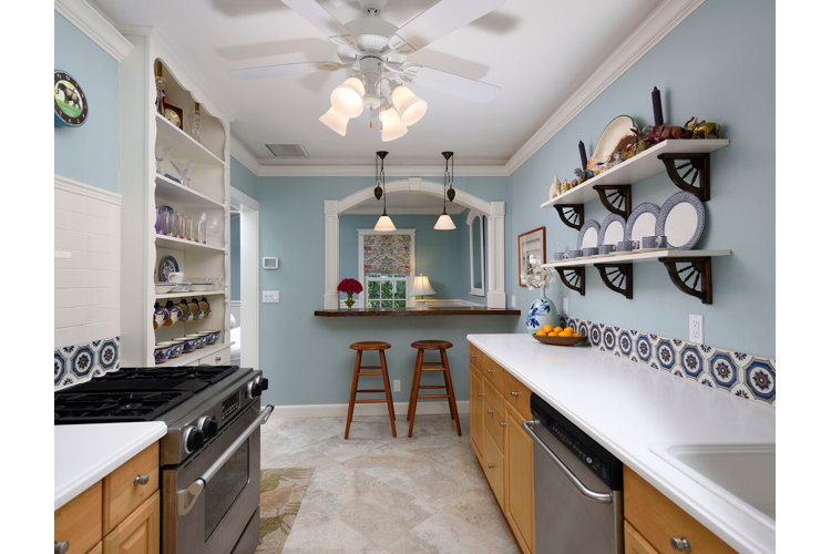 beautiful blue galley kitchen with white countertops and patterned tile backsplash
