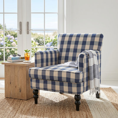 Fauteuil contemporain Lofties en polyester avec structure en bois de bouleau massif, coussins moelleux, garniture cloutée et détails capitonnés en losanges.