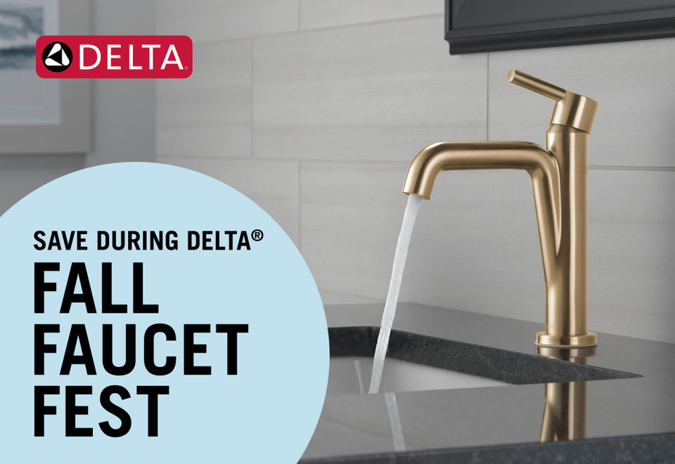 Brushed gold pull-down kitchen faucet dispensing water over a white quartz countertop in a modern kitchen.