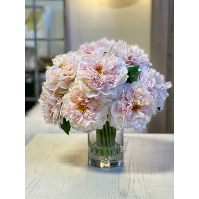 Pivoines disposées dans un vase en verre