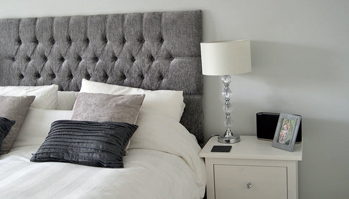 a beautiful new white bedside table with a crystal lamp atop it