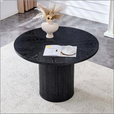 Une table de salle à manger circulaire moderne avec un diamètre de 42 pouces, avec des textures de couleur bois en forme d'éventail en diagonale, interprétant l'esthétique et la fonctionnalité de la maison.