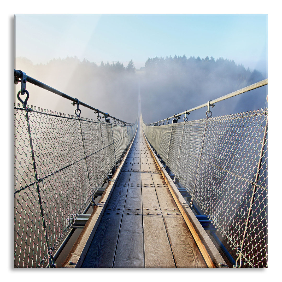 Glasbild Hängeseilbrücke im Nebelschimmer