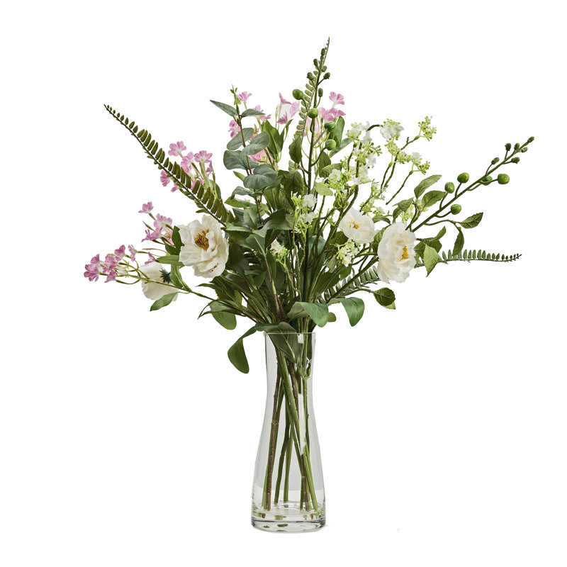 Mélange de fleurs blanches et roses dans un vase en verre