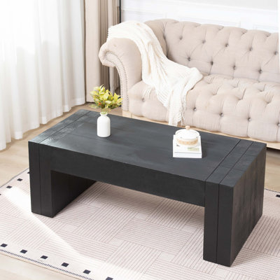 Table basse rectangulaire de 49 pouces avec pieds en bloc, fabrication en bois d'ingénierie, finition noire matte et conception discrète pour les salons de style campagne moderne.