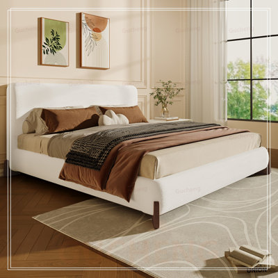 Élégant lit tapissier en tissu d'ameublement avec pieds en bois massif foncé, centre de chambre luxueux et confortable pour grand lit