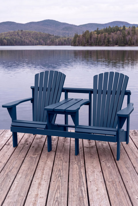 Banc Adirondack bleu avec tablette centrale sur un quai face à un lac et des montagnes.