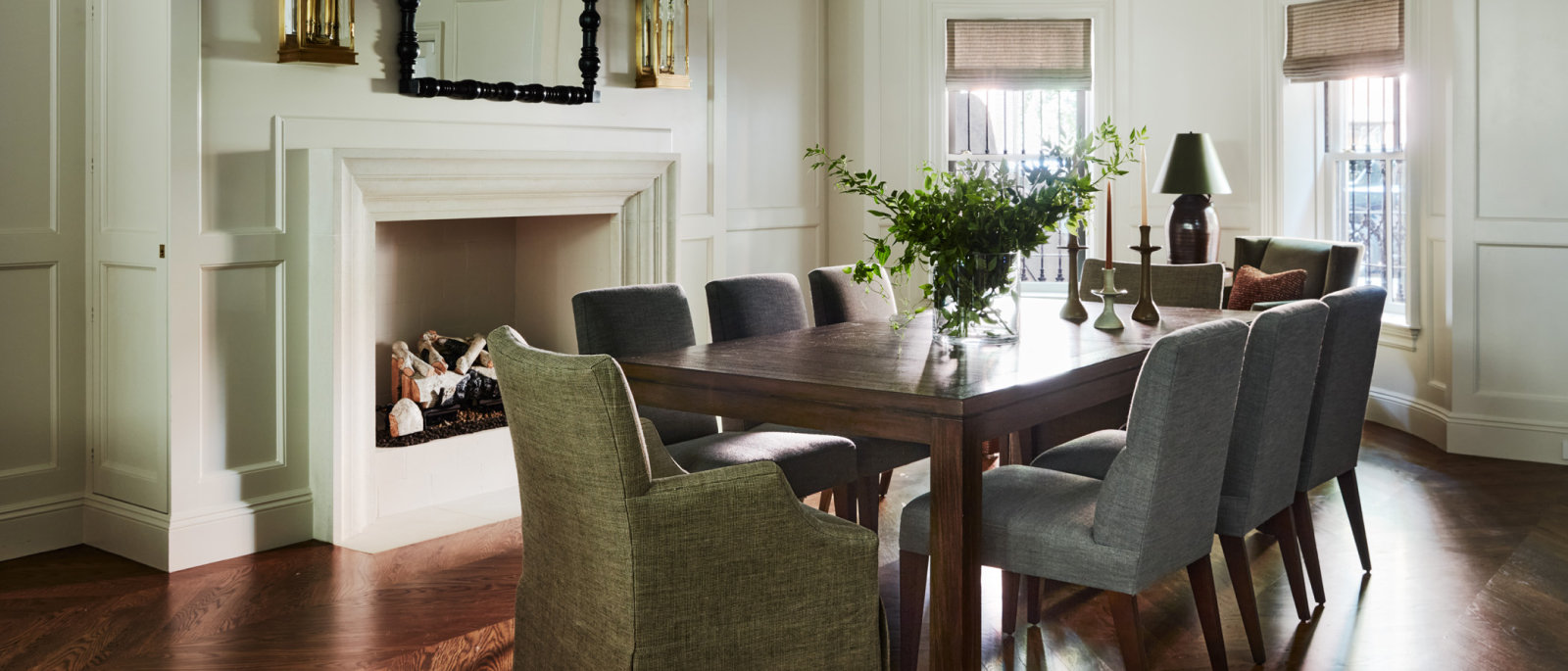 Dining room with fireplace, mirror, and rectangular table.