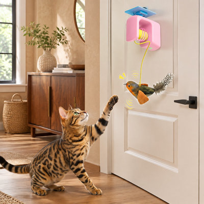 Un oiseau réaliste avec de l'herbe à chat et de la plume est intégré dans ce jouet suspendu rose pour permettre aux chats de jouer à l'intérieur d'un cadre de porte.