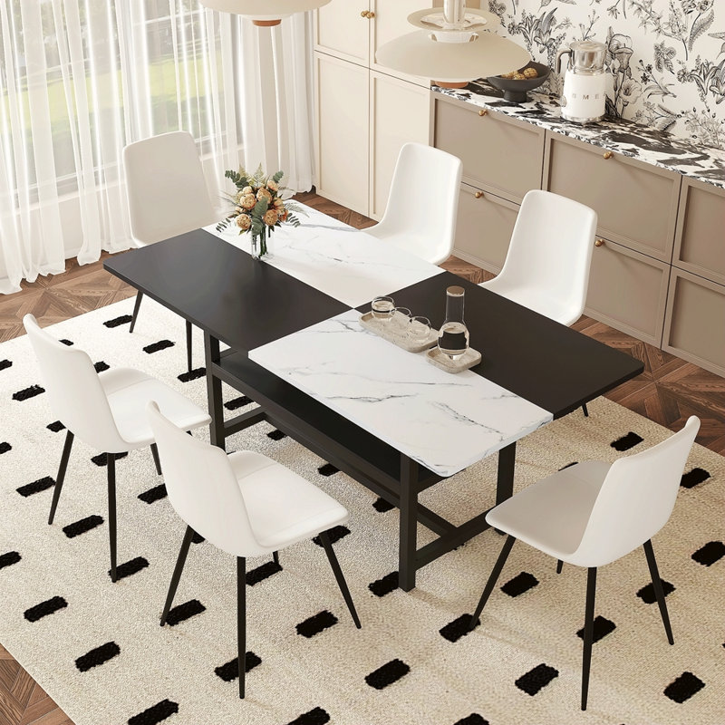 Table And Chair Set. Black Spliced Dining Table With Storage Function In The Middle Of The Table Legs.Paired With White Artificial PU Chairs With Curved Widened Cushion Design.