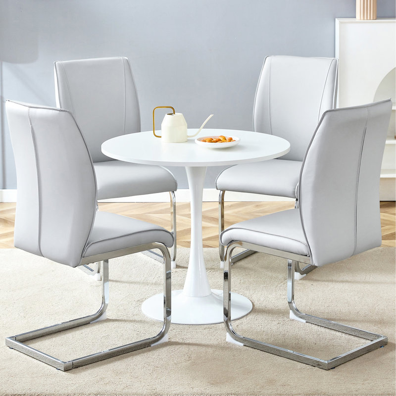 Ensemble de table et de chaises. Petite table ronde stable en forme de verre - 31,9 po x 31,9 po avec 2 chaises en polyuréthane gris clair douces et confortables avec des pieds arqués en métal argenté. Créez votre espace de luxe exclusif et discret.
