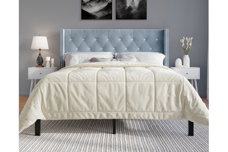 Soft blue glam bedroom set with a tufted headboard. A set of matching white nightstands.