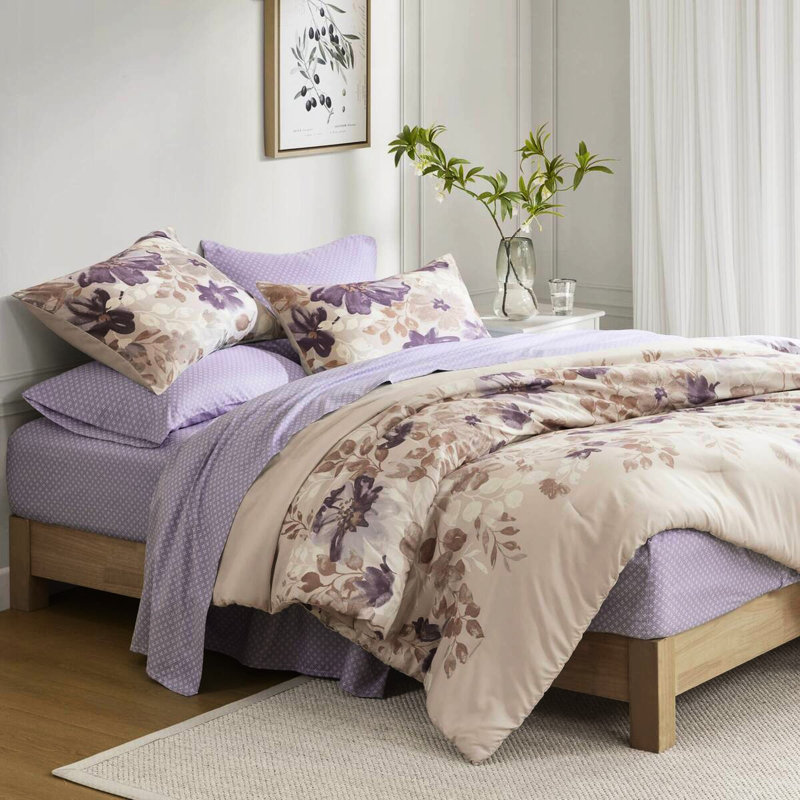 Très grand lit taupe avec édredon floral et draps à séchage rapide