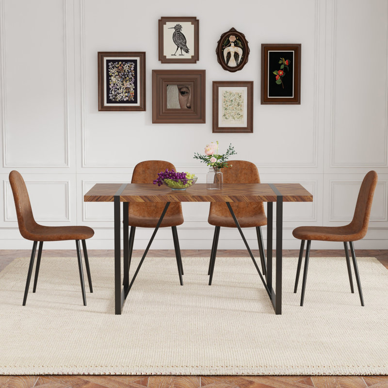Ensemble de table et de chaises.Une table de salle à manger rectangulaire rétro avec plateau en panneau de fibres à densité moyenne à motif de poissons et pieds en métal noir est jumelée à 4 chaises confortables en tissu brun avec des pieds en métal noir.