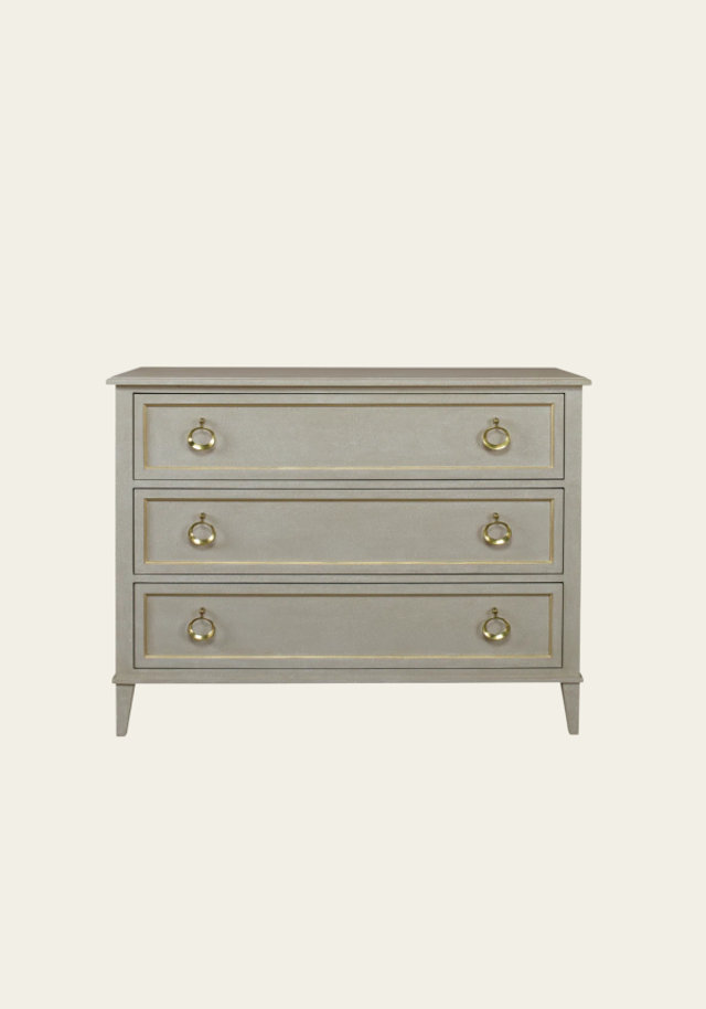 A chest of drawers in gray with gold accents.