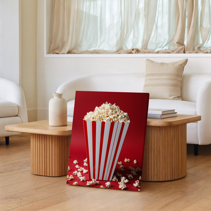 La toile crée une image en gros plan éclatante d'une boîte à popcorn rayée classique avec un popcorn blanc moelleux posé sur une toile