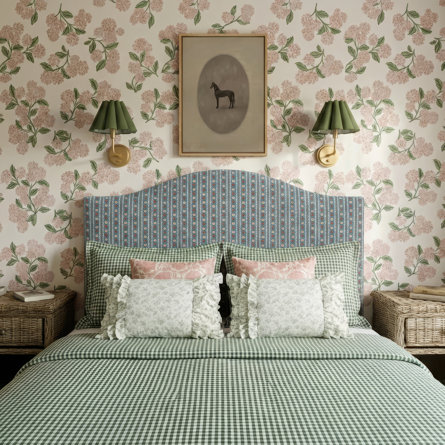Bedroom with floral wallpaper, horse artwork, and green gingham bedding.