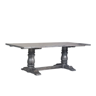 Table de salle à manger grise patinée avec plateau rectangulaire en bois massif et structure à deux piliers avec tréteaux en stratifié épais