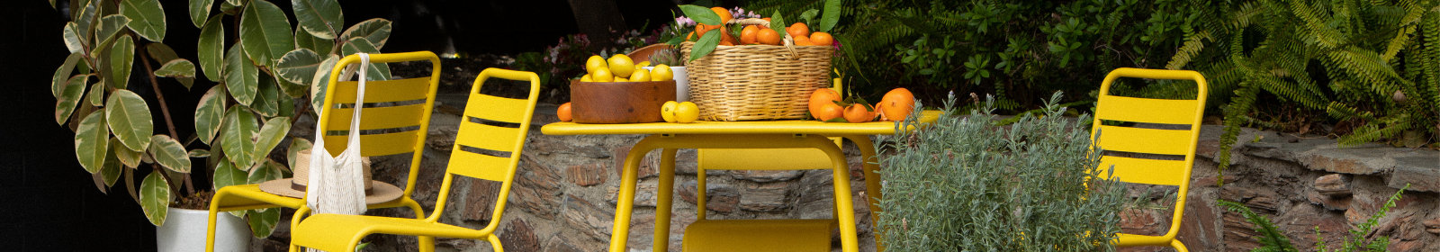 Bright yellow outdoor table and chairs in a beautiful rustic garden.