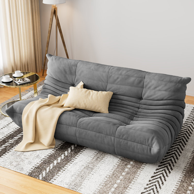Large gray tufted bean bag sofa with a low-profile, segmented design.
