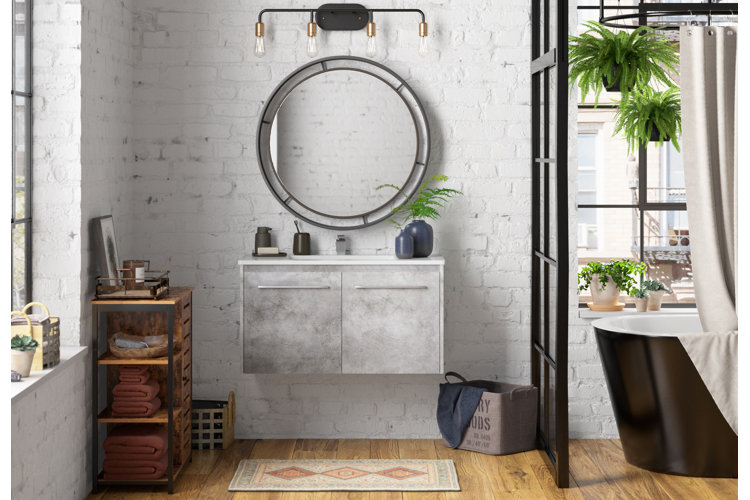 industrial loft bathroom with a floating vanity, round mirror, edison-bulb vanity lighting, and a wood linen cabinet