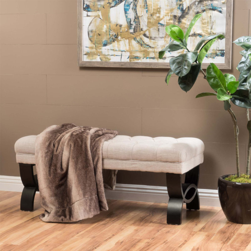 Luxueux repose-pieds capitonné classique avec coutures en losanges et pieds semi-circulaires modernes pour une décoration intérieure élégante