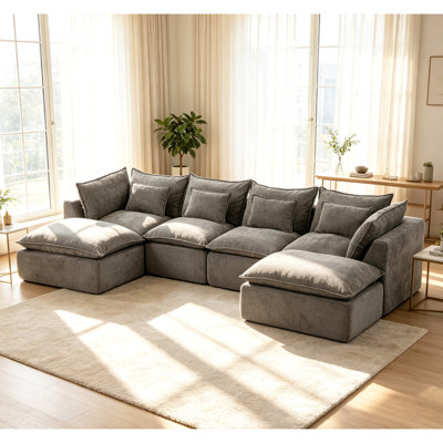 Canapé d'angle modulaire surdimensionné Cloud Couch de 330 cm de large, offrant un confort optimal et une assise large et profonde. Revêtement en tissu gaufré, 4 places avec 2 poufs.